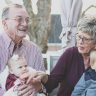 Grandmother and Grandfather Holding Child on Their Lap