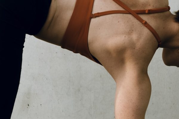 a woman in a brown bikini doing a handstand