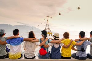 people holding shoulders sitting on wall