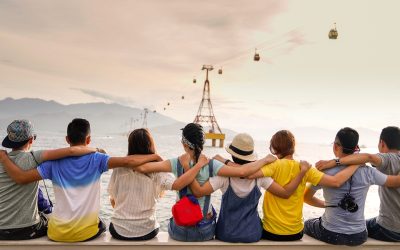 people holding shoulders sitting on wall